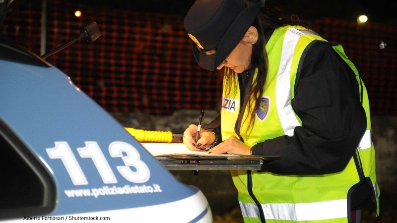 Pattuglia di polizia con agente donna che compila verbale